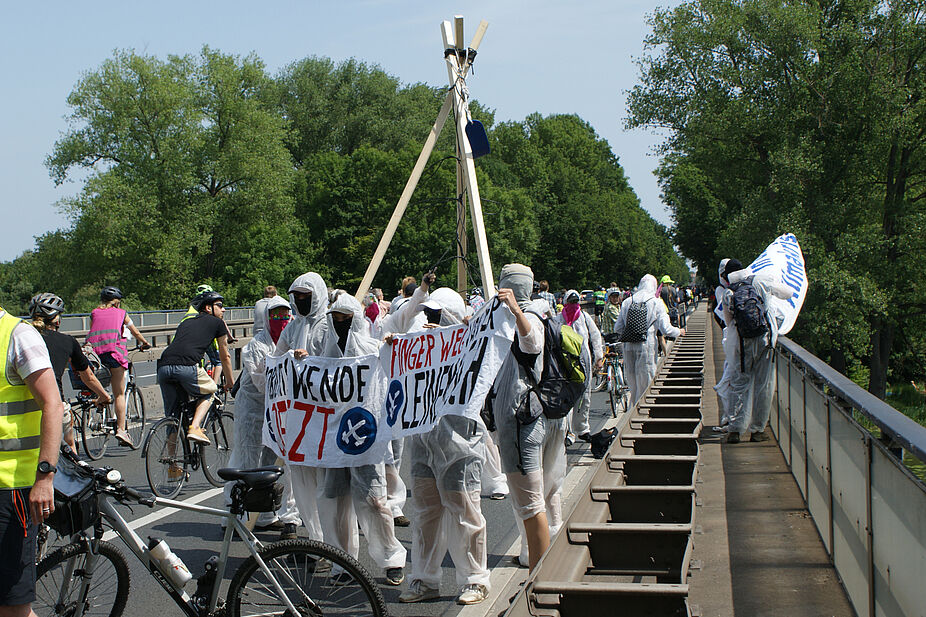 Bannerdrop und Tripodbau Ende Gelände baut den Tripod auf und befestigt ein Banner am Brückengeländer.